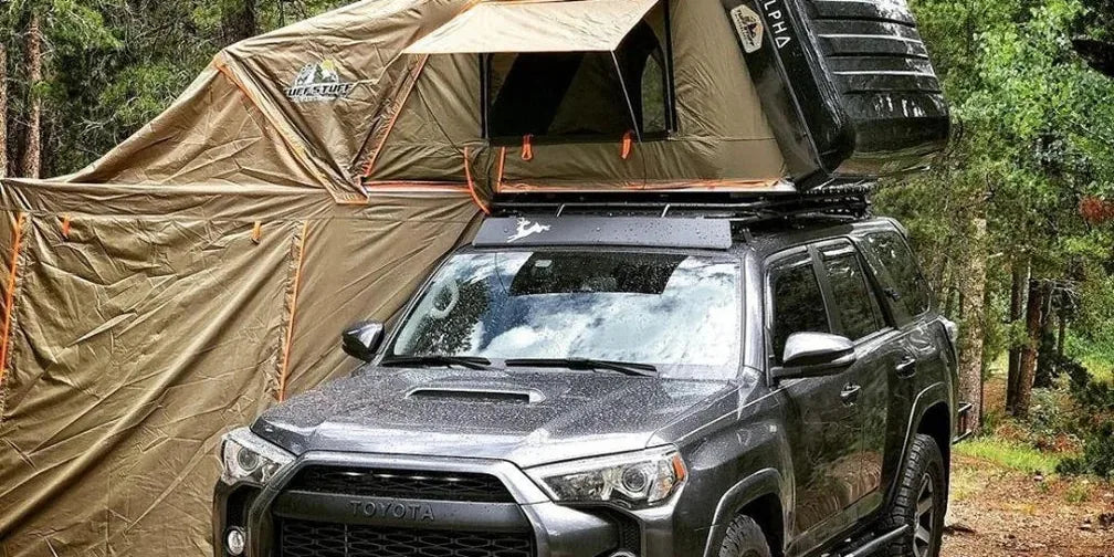 Tuff Stuff Alpha hardshell rooftop tent with annex room on a gray Toyota 4Runner in the forest