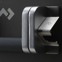 Metallic car mount holder on a dark background with a brand logo.