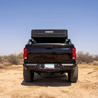 Black pickup truck with a bed cover in a desert landscape
