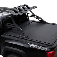 Black truck bed with a tonneau cover and roof rack on a white background