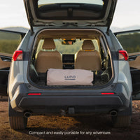 Open car trunk with a Luno product inside, set against a natural outdoor background.