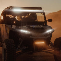Off-road vehicle with illuminated 40 inch LED light bar driving at sunset on a dusty trail