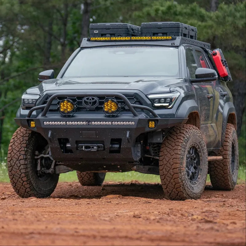 Gray 6th Gen Toyota 4Runner built with a C4 Fabrication bull bar, roof rack and lights on red dirt