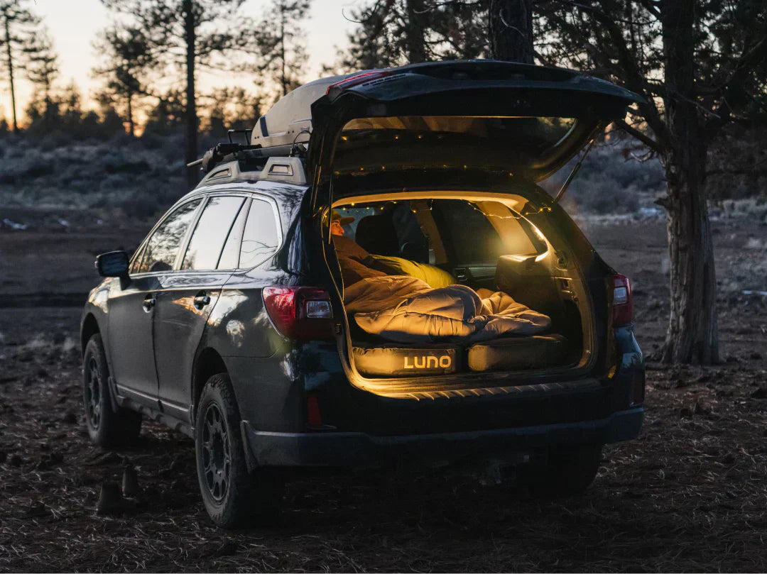 Subaru Outback in darken wood setup for a comfortable night of car camping