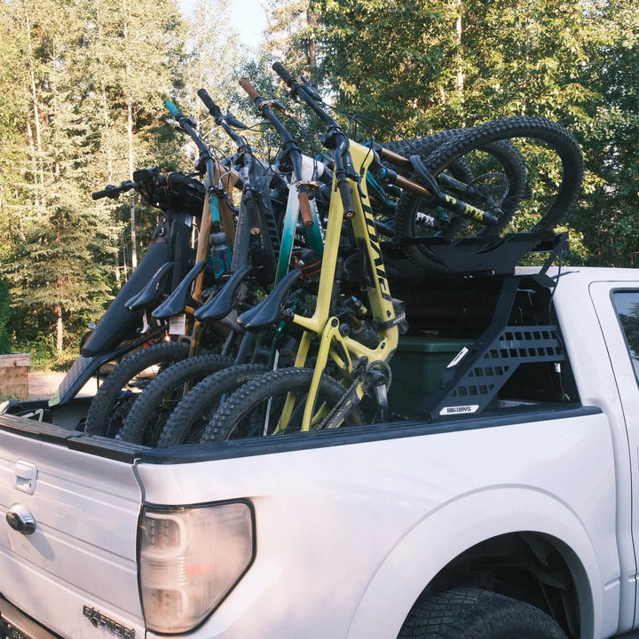 Big Days Chase Rack holding bikes upright in the bed of a white Ford F-150 Raptor with the tailgate closed