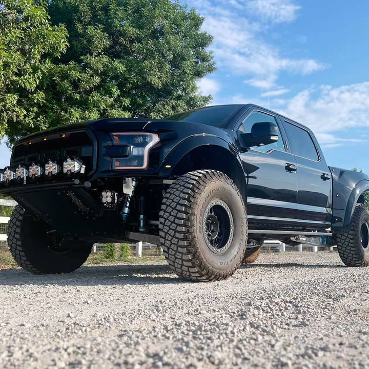 Ford Raptor with offroad tires on gravel
