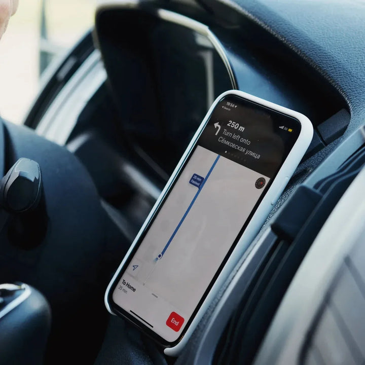 Phone in a dash mount showing a navigation map on an off-road drive