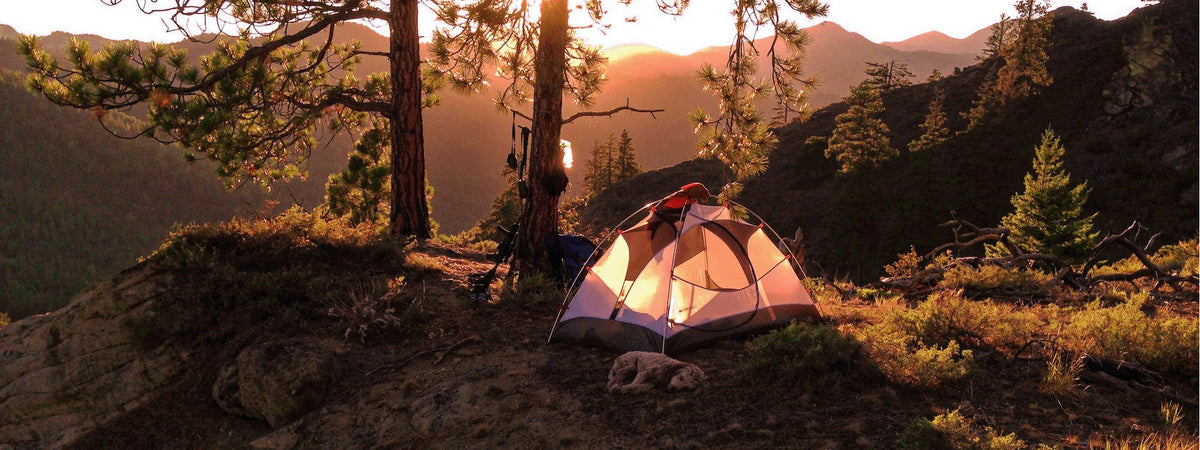 Campsite at sunset with camping gear laid out for car camping and overlanding trips