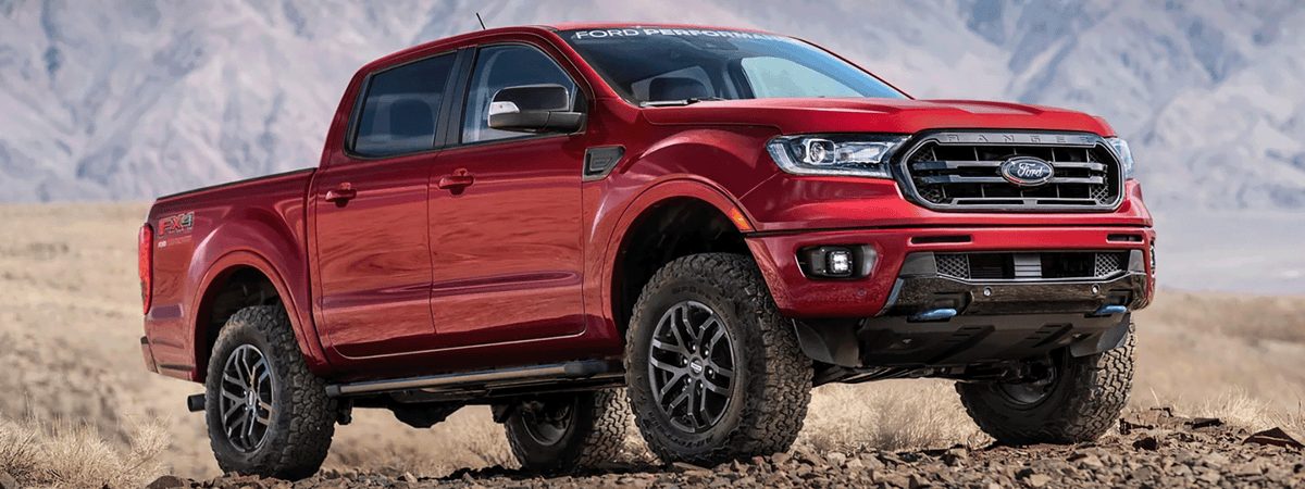 Ford Ranger with rooftop tent and bed rack on gravel road