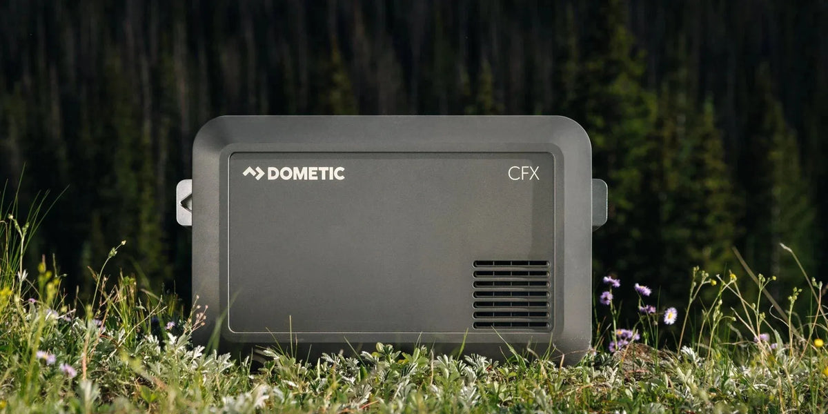 Dometic CFX portable fridge freezer sitting in a mountain meadow