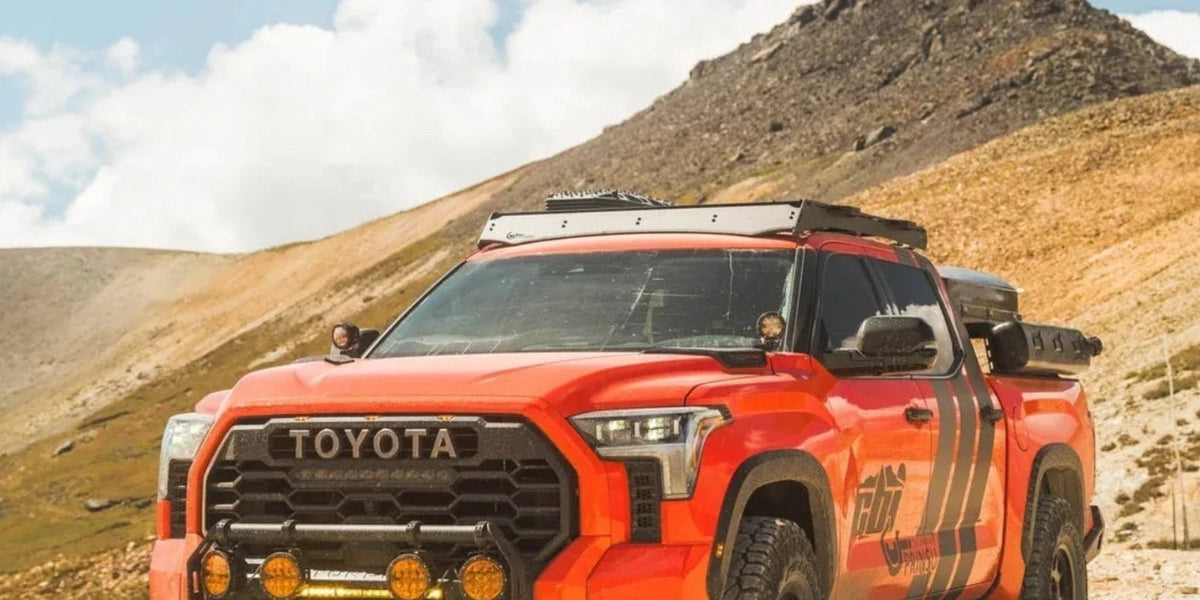 Orange Toyota Tundra CrewMax with a Prinsu Pro roof rack in the desert hills