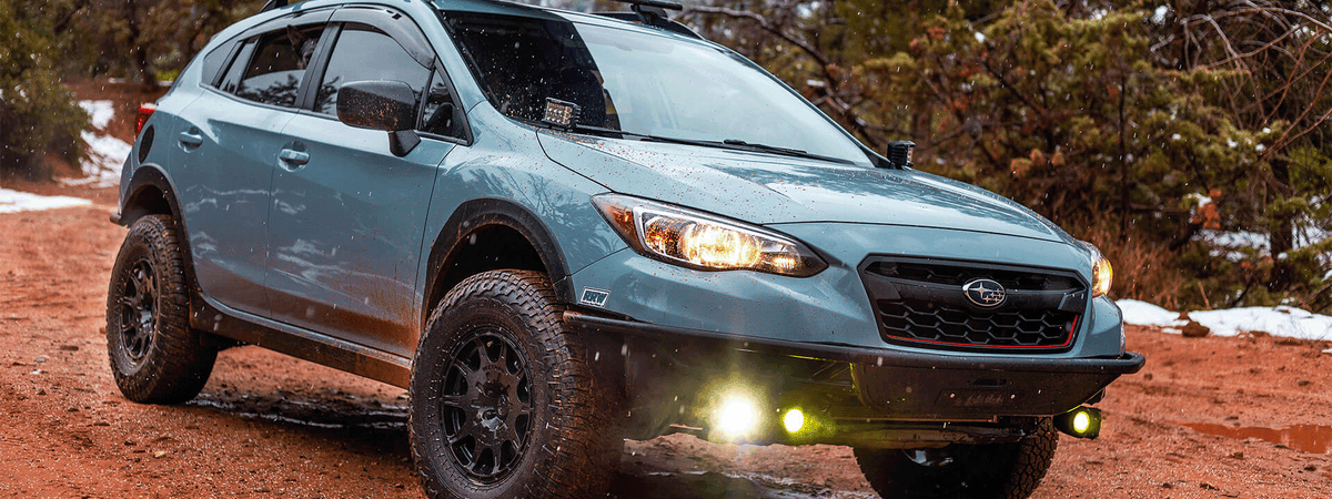 Subaru Crosstrek off-road on dirt trail with roof rack and camping gear, Gearlanders