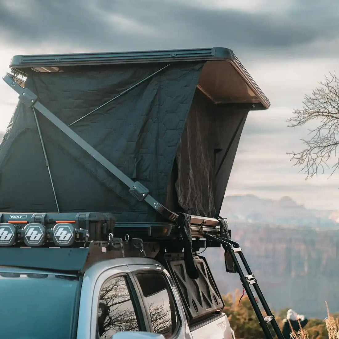 Free Spirit Evolution XL rooftop tent deployed on an overland truck overlooking a desert canyon