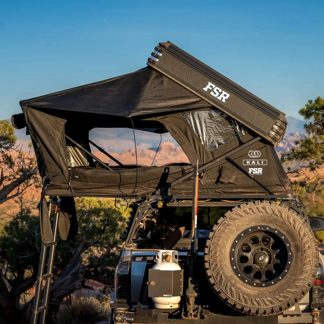 Toyota Tacoma with Free Spirit Kali rooftop tent open on a bed rack