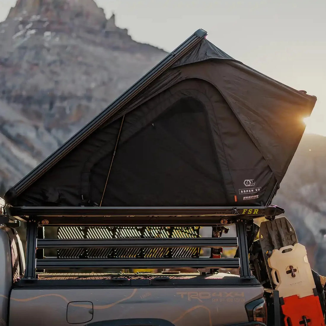 Free Spirit Aspen Pro XL rooftop tent open on a truck bed rack at sunset in the mountains