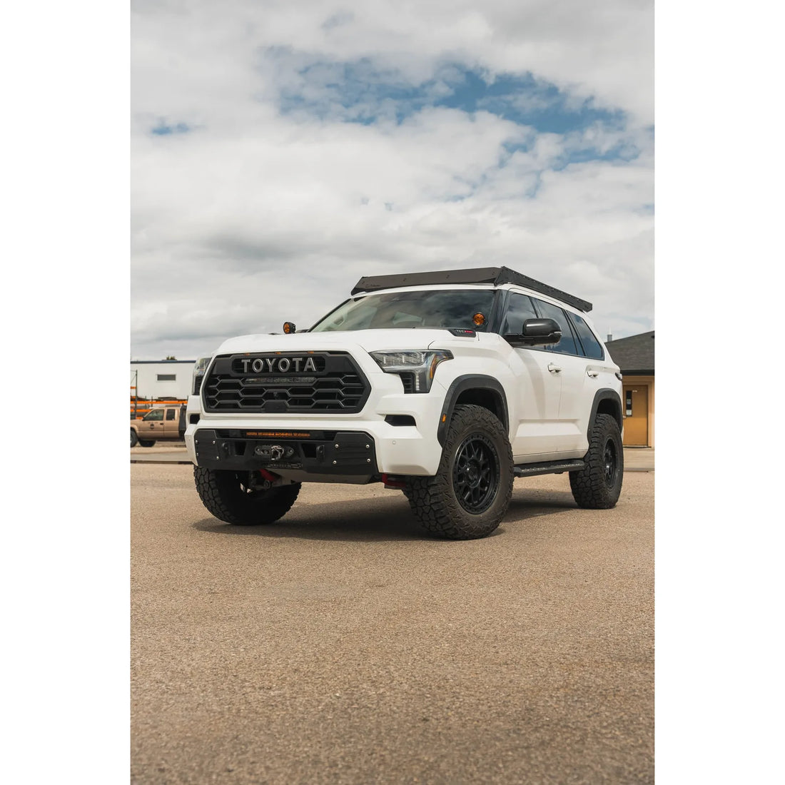 White Sequoia TRD Pro with Prinsu Pro roof rack outdoors, front angle