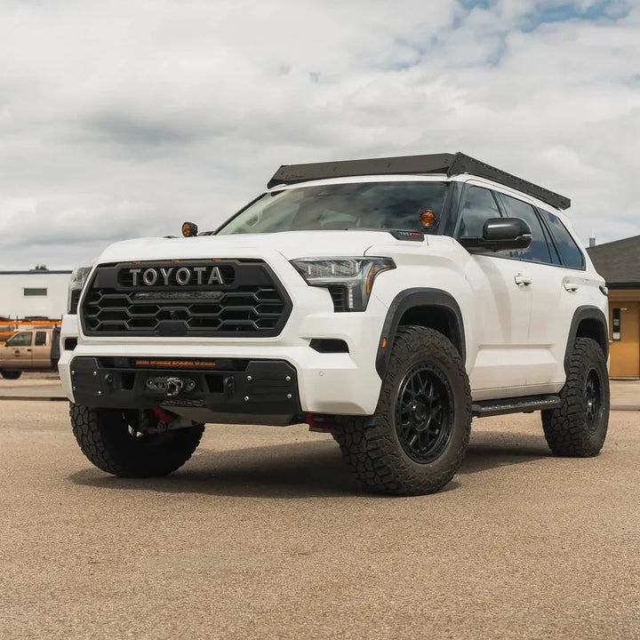 White Sequoia TRD Pro with Prinsu Pro roof rack outdoors, front angle