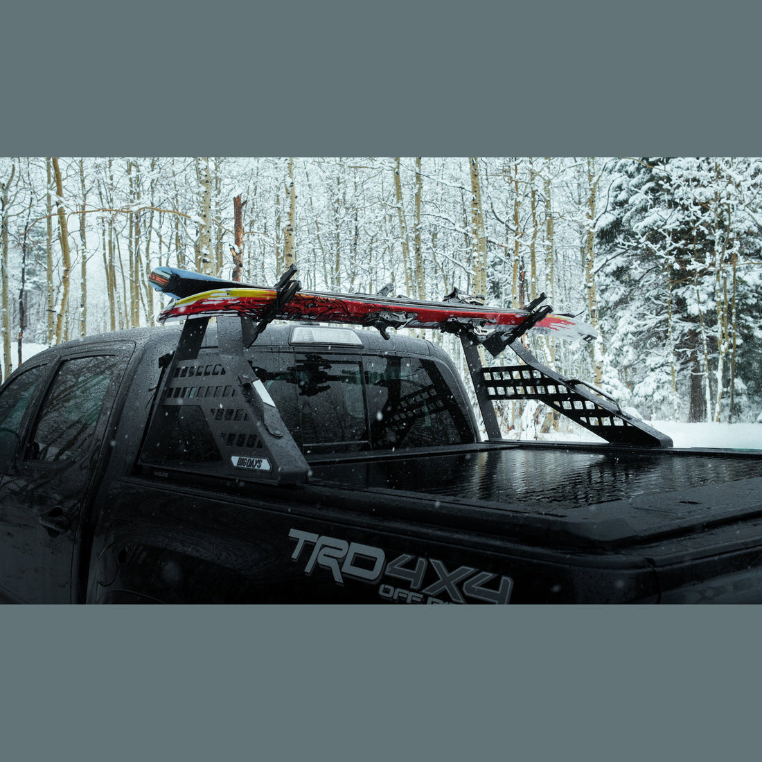 Skis and snowboards strapped in a truck bed on Big Days T-track mounts