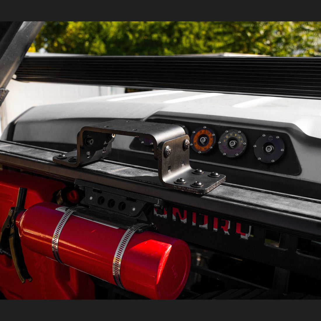 Offset adapters bolted under motorcycle mounts on the upper crossbar