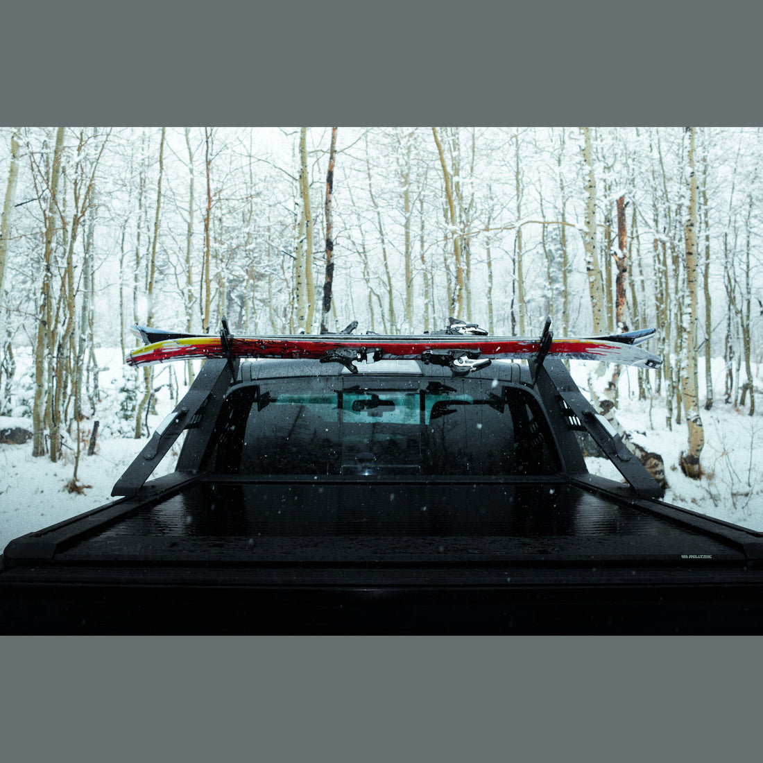 Pair of ski snowboard brackets bolted to a Chase Rack upper bar