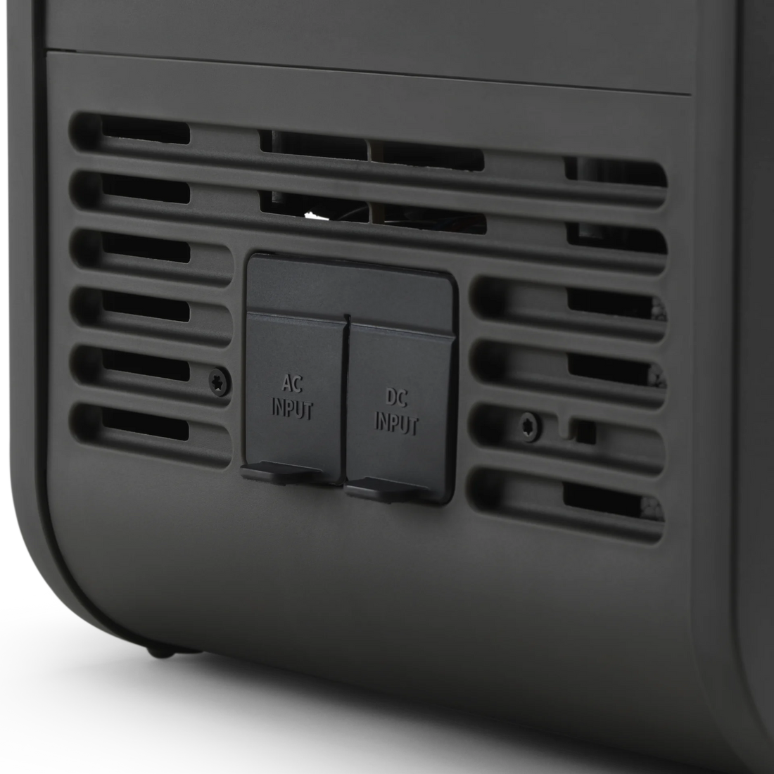 Black electronic device with AC and DC input ports on a white background