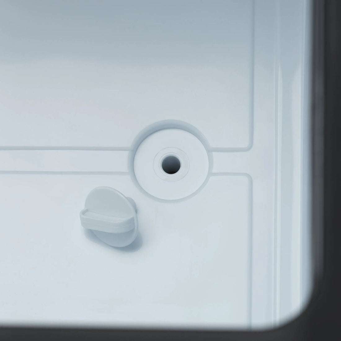 Close-up of a cooler drain plug and interior, camping gear detail