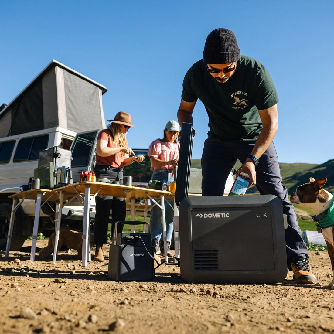 Group of people around a Dometic CFX cooler outdoors.