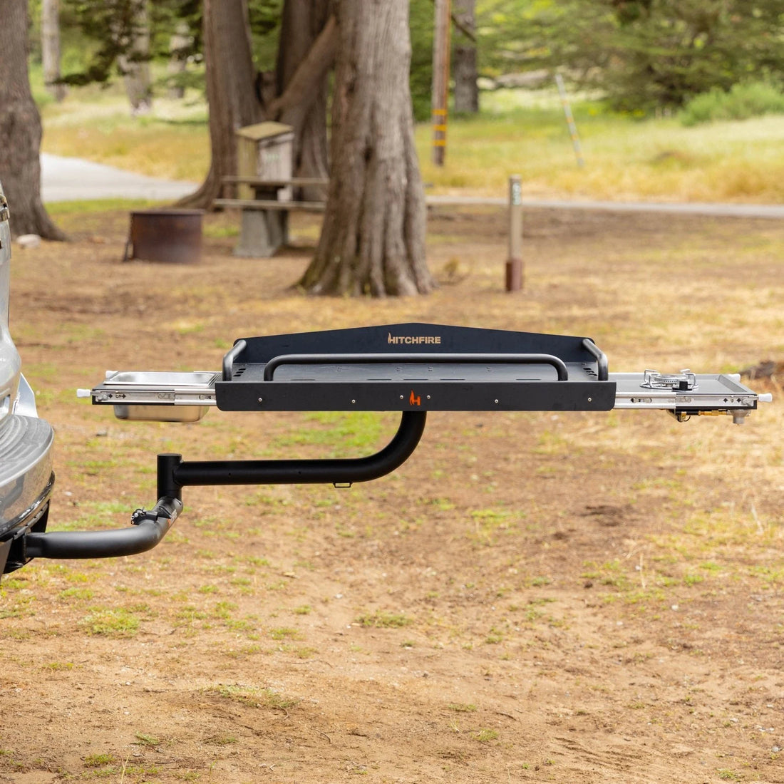Tow bar attached to a vehicle in a natural setting with trees and grass.