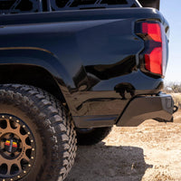 Black off-road vehicle with a spare tire on a dirt road