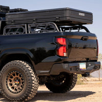Black truck with a roof rack in a desert setting