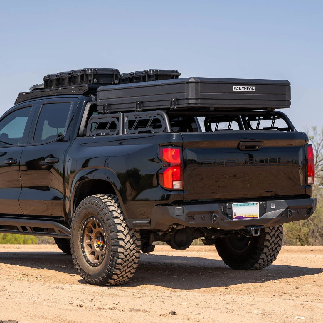Black pickup truck with roof rack on a dirt road