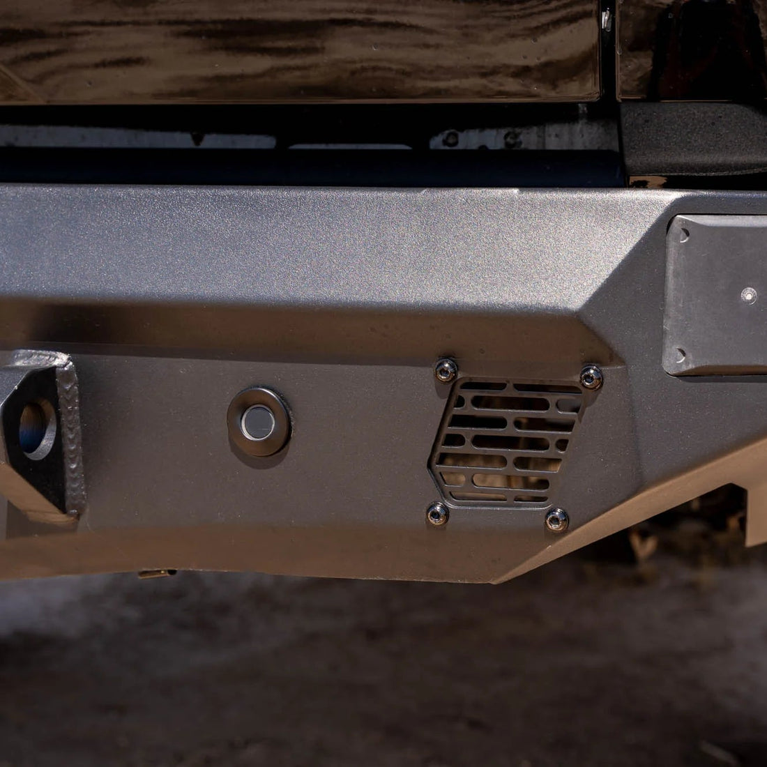 Close-up of a vehicle bumper with metallic finish