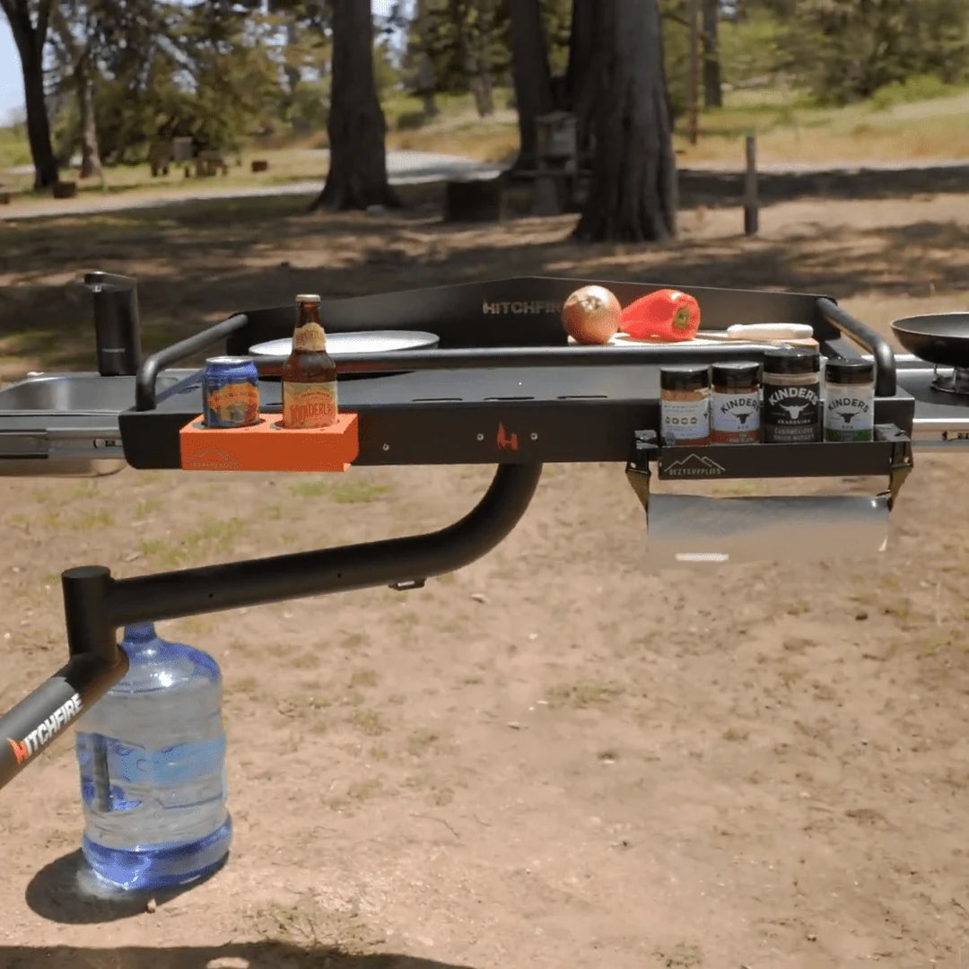 Trailer hitch with camping gear attached on a dirt road