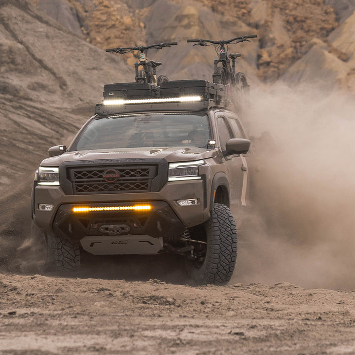 SUV driving through a desert landscape with mountains in the background