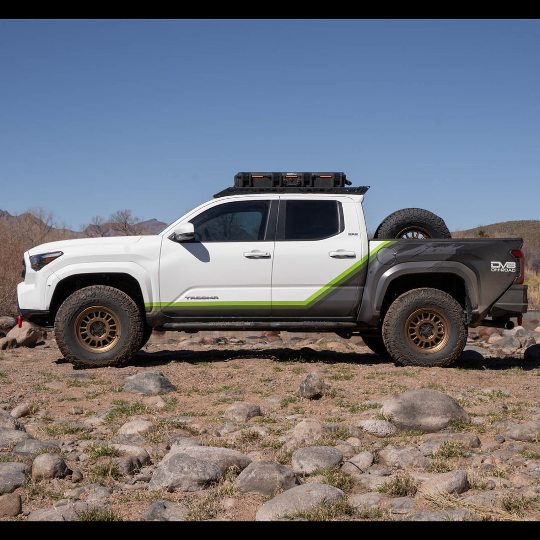 White and gray off-road truck with green accents on rocky terrain