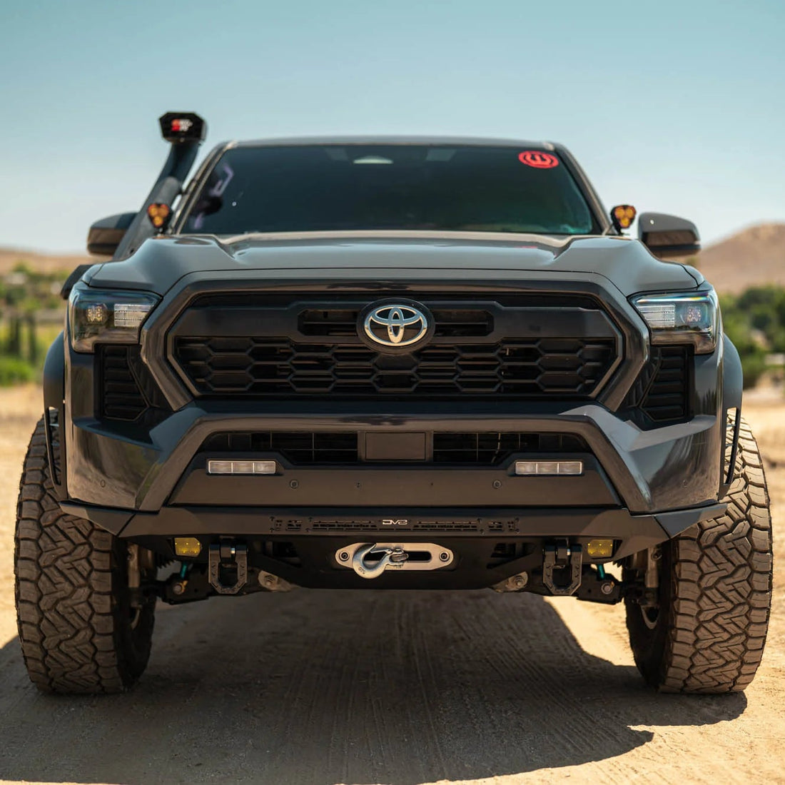 Toyota truck on a dirt road with a scenic background
