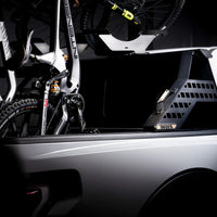 Bicycle mounted on a car roof rack with a dark background