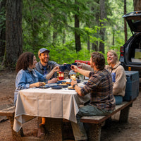 Family gathered around the camp table