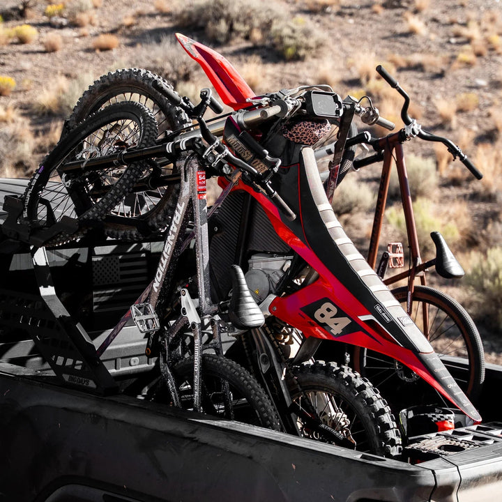 dirt bike and two mountain bikes in a truck bed bike rack