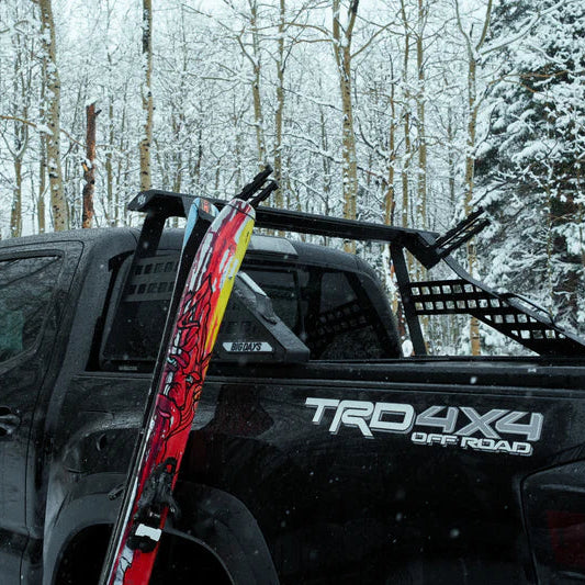 Black truck with 'TRD 4X4 Off Road' logo in a snowy forest