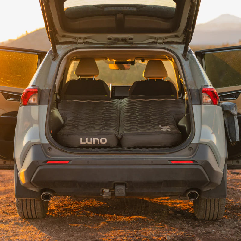 Car trunk with LUNO sleeping pad in a desert setting