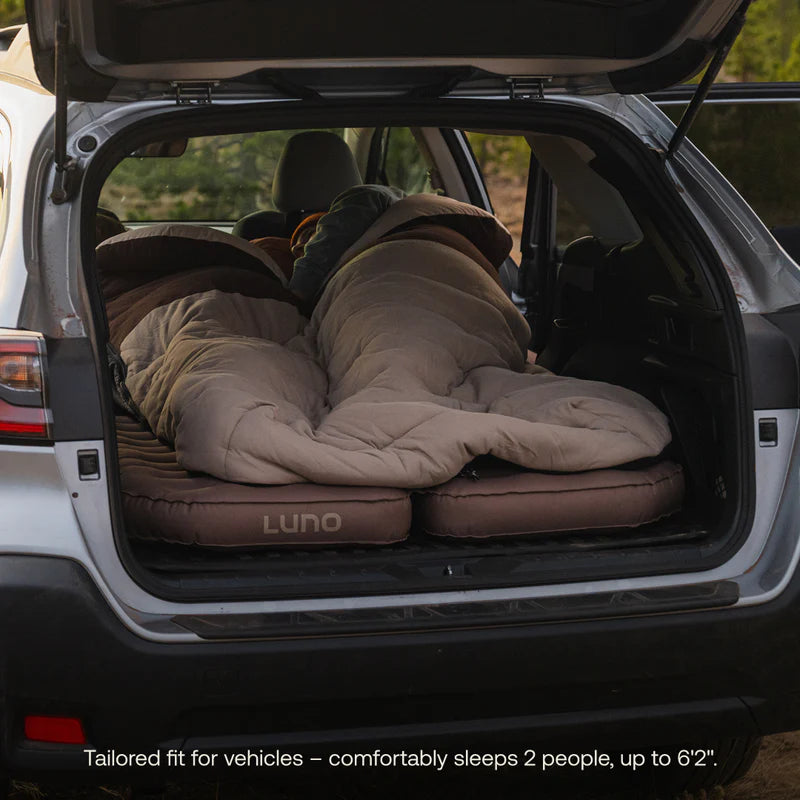 Sleeping bag set up in the back of a car with &