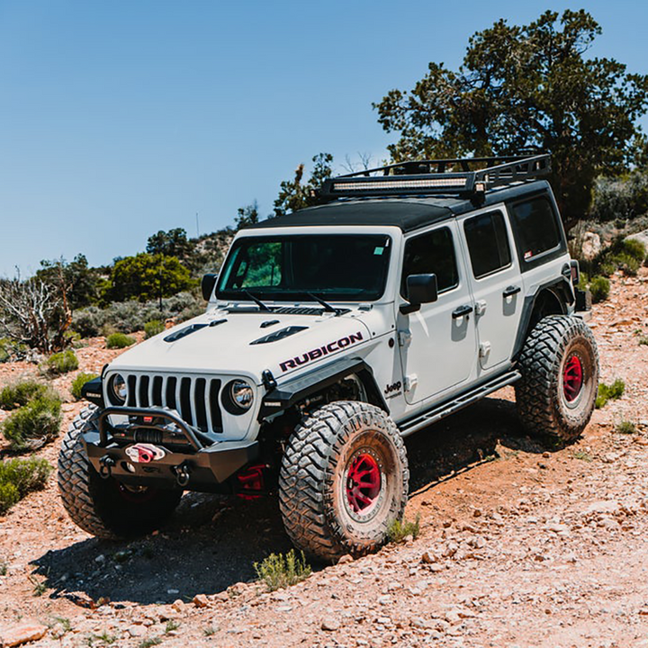 Jeep Rubicon with off-road gear navigating a dirt trail