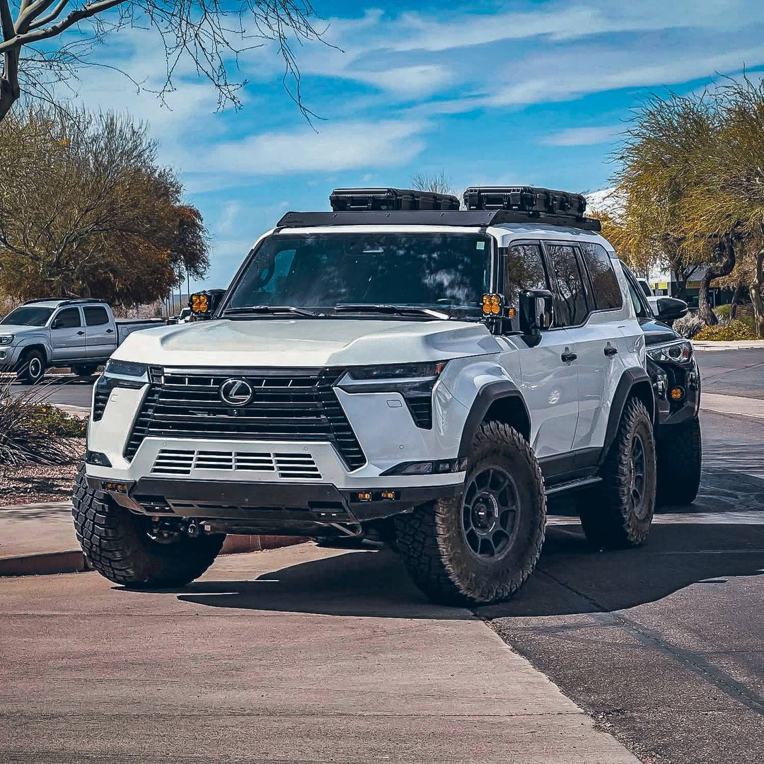 White Lexus GX 550 with a roof rack parked on a street