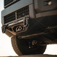 Close-up of a rugged vehicle's front bumper with a sunset in the background