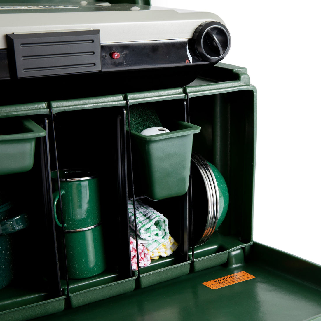 Green storage unit with compartments containing various items on a white background