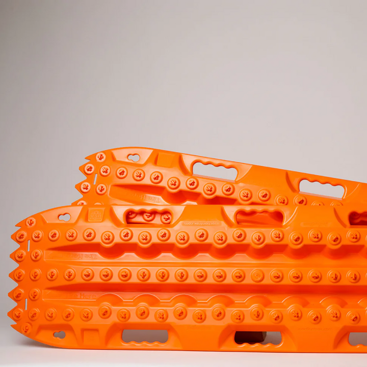 Close-up of orange ActionTrax recovery boards with textured traction lugs.