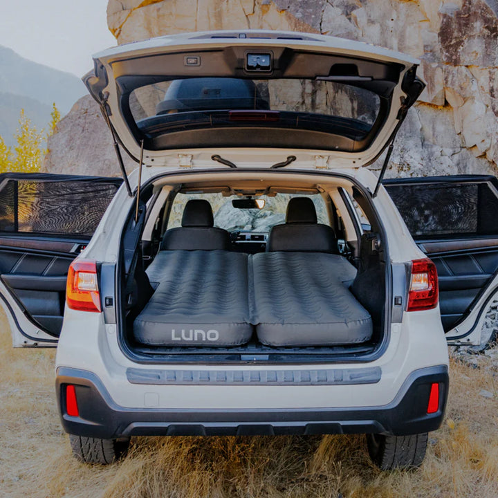 Inflatable camping mattress set up in SUV trunk outdoors, ideal for car camping and overlanding