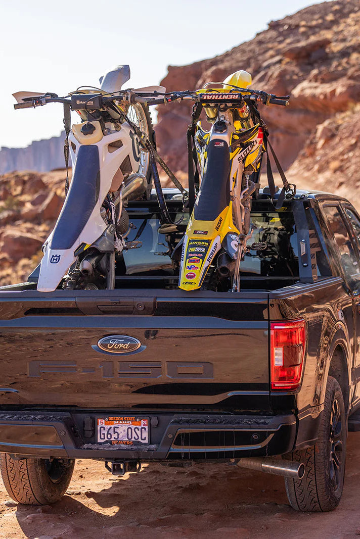 Two trucks with off-road vehicles on a desert trail
