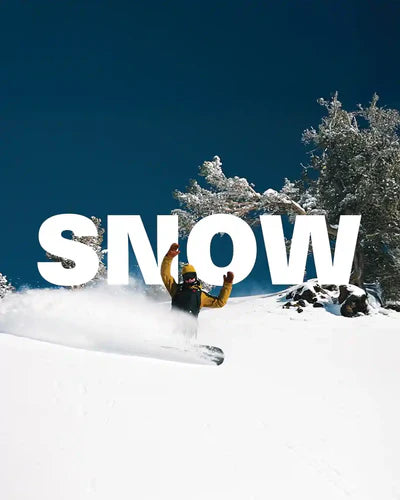 Person buried under snow with 'SNOW' text in a snowy landscape